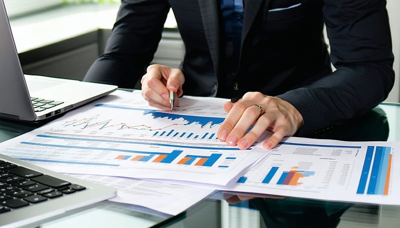 Professional bookkeeper working remotely with financial documents and a laptop Professional bookkeeper working remotely with financial documents and a laptop